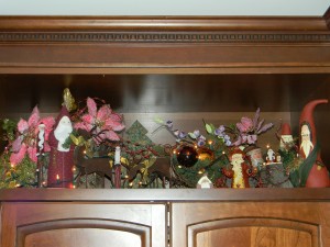 Christmas decorations, assorted santas above TV armoire