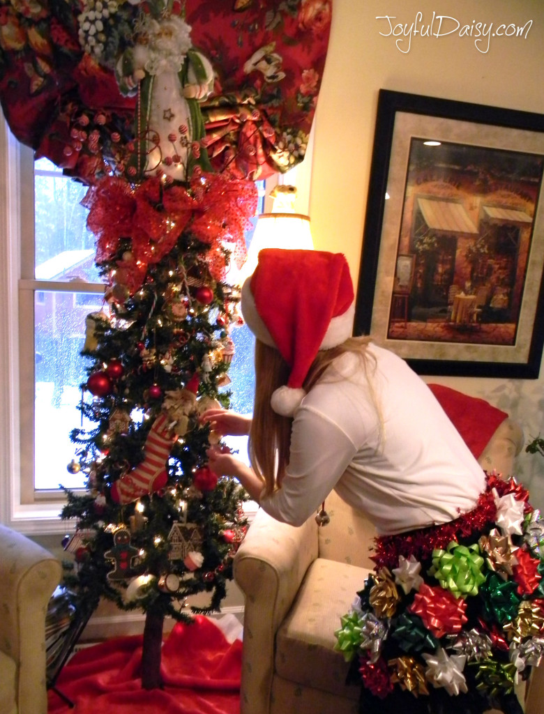 elf caught decorating santa tree